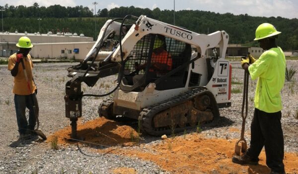 Commercial Fencing Being Installed With Heavy Duty Equipment Digger